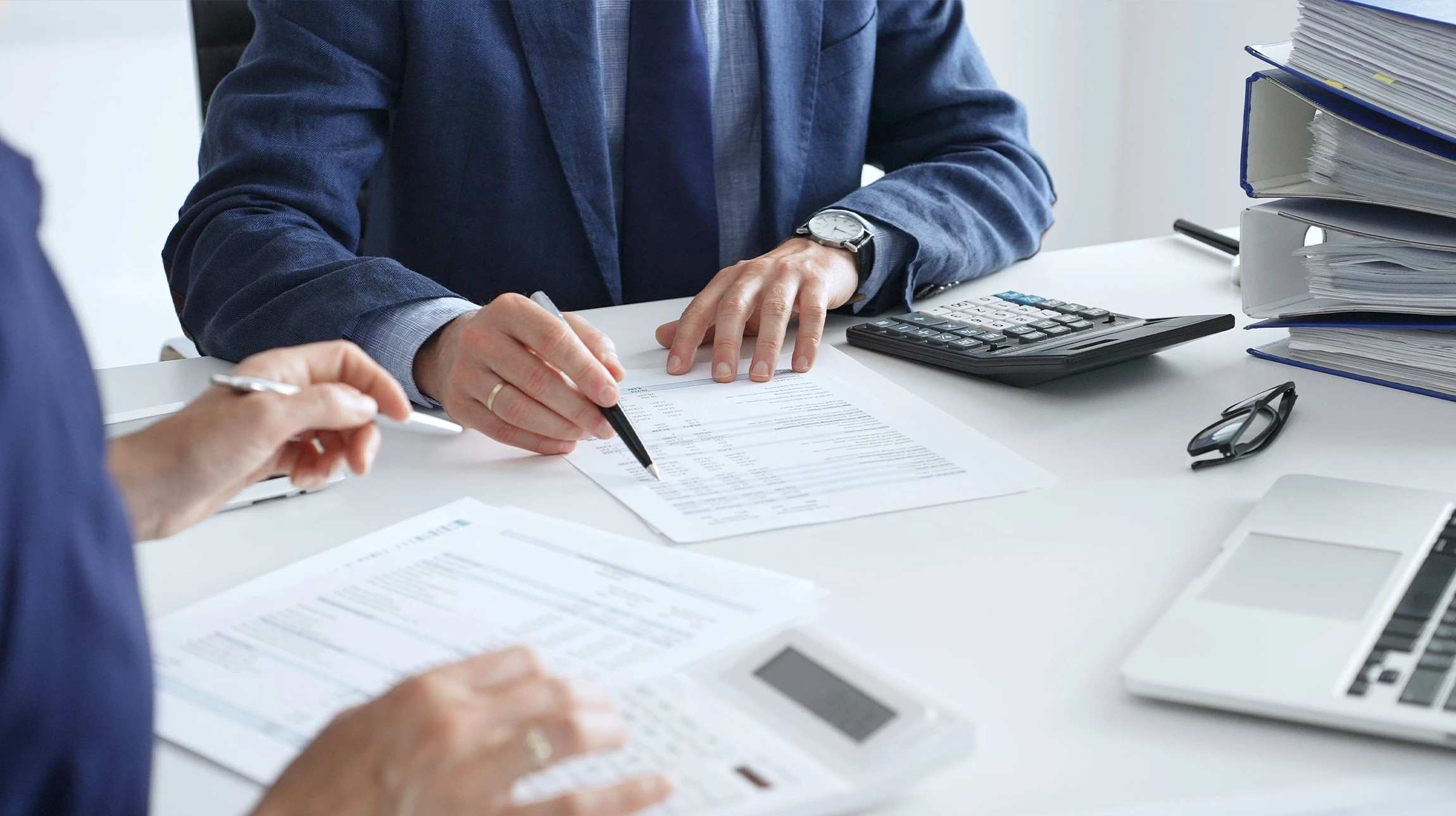 Homme travaillant sur ordinateur portable dans bureau moderne, analysant des graphiques financiers et tableaux de bord comptables à l'écran