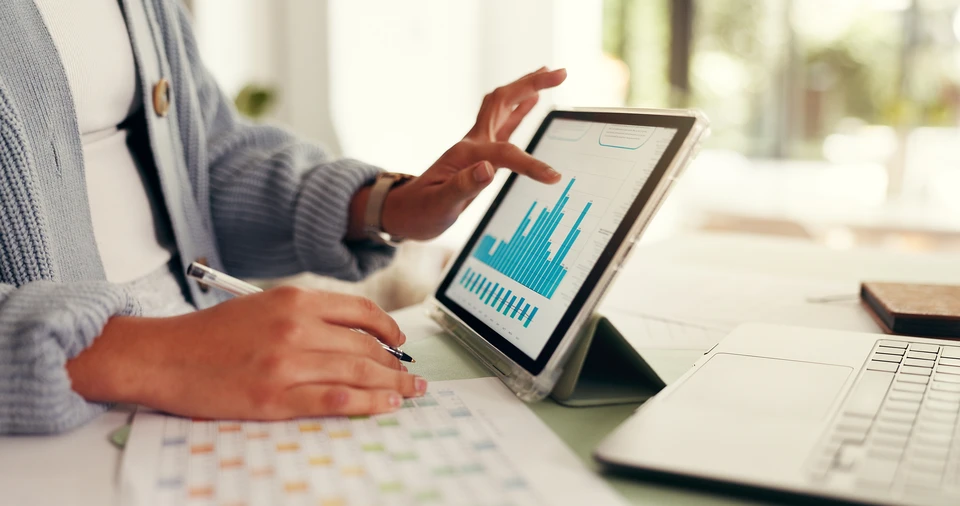 Deux hommes d'affaires en chemises bleues analysent des données financières dans un bureau moderne