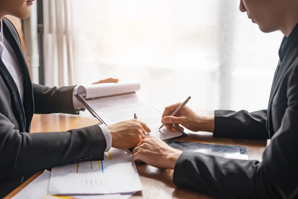 Jeune avocate professionnelle souriante dans bureau moderne, tenant marteau de juge et dossier juridique